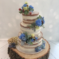 Naked wedding cake with blue flowers