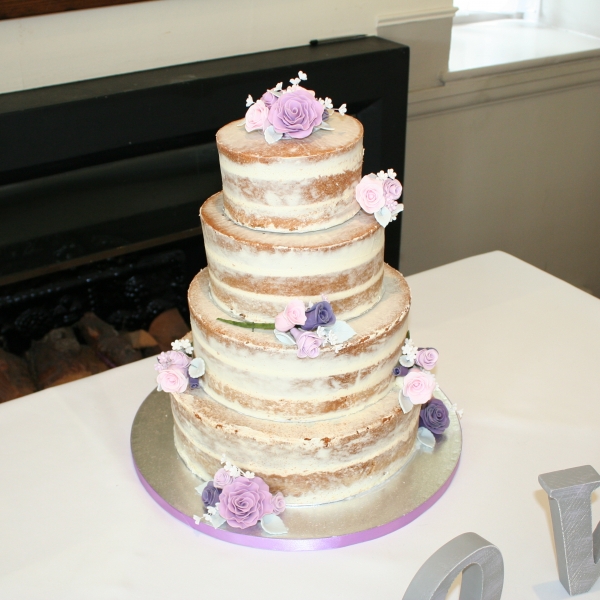 Semi-naked wedding cake decorated with sugar flowers