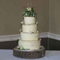 4 tier semi-naked cake with green/cream flowers &amp; topper